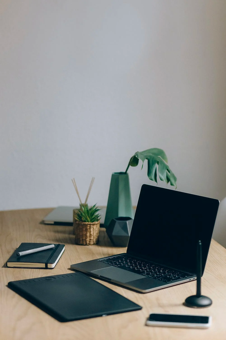 A broken laptop placed on a table along with other devices.